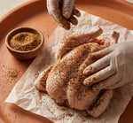 Costack Chicken and Turkey Seasoning being rubbed onto raw chicken before roasting